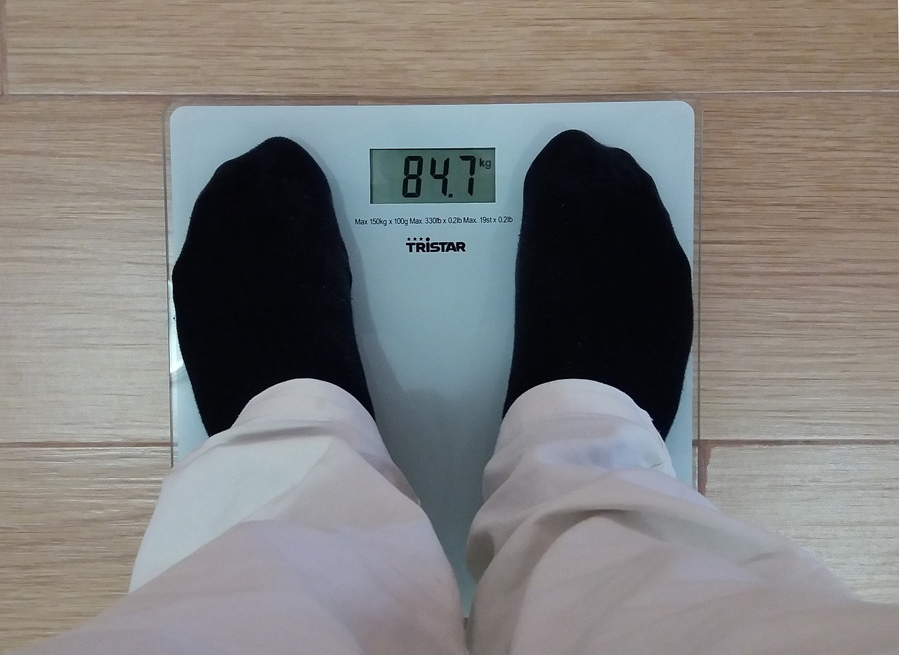 Egy férfi egy mérlegen, amely 84,7 kilogrammot mutat